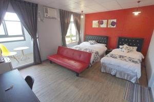une chambre d'hôtel avec deux lits et un canapé rouge dans l'établissement Light Shadow, à Budai