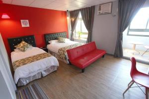 布袋鎮的住宿－光影民宿，红色的房间,设有两张床和一张红色的沙发