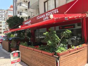 um restaurante com um toldo vermelho numa rua em Adana Hostel 1 em Adana