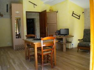 een eetkamer met een tafel en stoelen en een bureau bij Au col de Cygne in Blanzac-lès-Matha