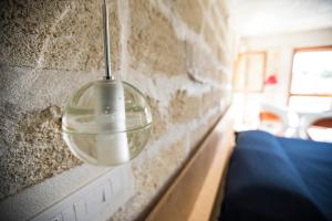 a glass light hanging on a stone wall at Cave Bianche Hotel in Favignana