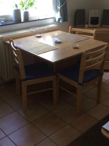 a wooden table and two chairs at a table at Hoeve Het Verre Einder in Heythuysen