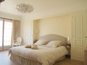 ein Schlafzimmer mit einem großen weißen Bett und einem Kronleuchter in der Unterkunft La maison de Concise - non adapté pour les enfants ni pour les mariages in Thonon-les-Bains