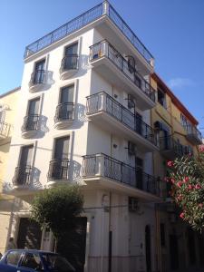 a white building with balconies on the side of it at Bianco&Nero 61 Apartament in Margherita di Savoia