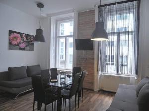 een woonkamer met een tafel en stoelen en een bank bij Gozsdu Entertainment District Apartment in Boedapest