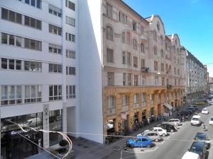 uitzicht op een straat met gebouwen en auto's bij Gozsdu Entertainment District Apartment in Boedapest
