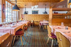 a row of tables in a restaurant with pink tablecloths at Eiger Guesthouse in Mürren