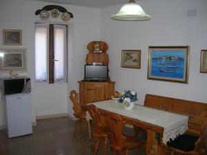 une cuisine avec une table et une télévision, ainsi qu'une table et des chaises dans l'établissement Ex B&B La Bicocca - Via Umberto 15, IUN S1733, à Sorso
