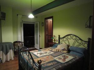 a bedroom with a bed in a room with green walls at La Casona de Collado in Hoyos del Collado