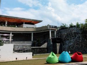 three colored bags sitting in front of a building at TechieRoom Kotlin at Clove Garden Residence in Bandung