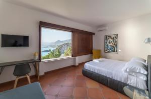 a bedroom with a bed and a large window at Villa Crawford in San Nicola Arcella