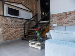una sala de estar con una escalera y un jarrón de flores sobre una mesa en Sunset Suites en Sarandë