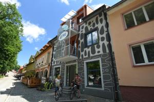 two people riding bikes in front of a building at Apartments Otre Frymburk in Frymburk