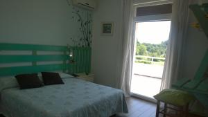 una camera con un letto e una grande finestra di Hotel Cubamia a Romano D'Ezzelino