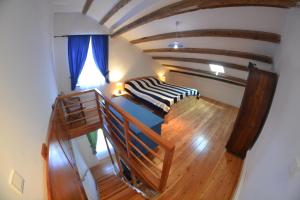 an attic room with a bed and a staircase at Country House Vrsani in Rab