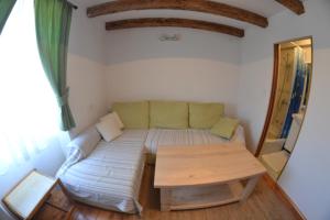 ein Wohnzimmer mit einem Sofa und einem Tisch in der Unterkunft Country House Vrsani in Rab