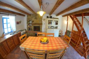 a kitchen with a table with a bowl of fruit on it at Country House Vrsani in Rab