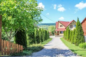 une allée avec une rangée d'arbres à côté d'une maison dans l'établissement Sóvidék Guesthouse, à Praid