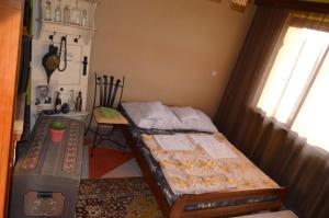 a bedroom with two beds and a table and a window at Farebný Penzión in Krásnohorské Podhradie