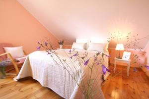 sypialnia z łóżkiem z białą pościelą i kwiatami w obiekcie Mazurska Sielanka w mieście Snopki
