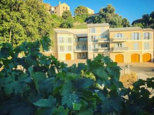 a building with a bunch of plants in the foreground at Casale a Figa Bianca in Patrimonio