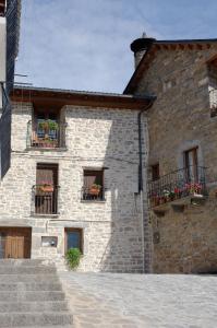 a stone building with flower boxes on the windows at Apartamento el Patio Casa Cajal in Torla