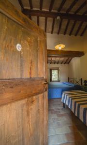 Monte San PietrangeliにあるAgriturismo Fonte Carellaのベッド付きの客室内の大きな木製ドア