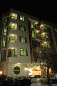 亚的斯亚贝巴Hera Addis Hotel的一座高楼，前面停着汽车