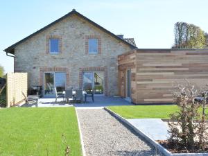 uma casa de pedra com uma mesa e cadeiras num quintal em Tasteful Holiday Home in Waimes with Sauna em Ovifat