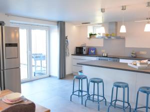 a kitchen with a counter and stools in it at Tasteful Holiday Home in Waimes with Sauna in Ovifat