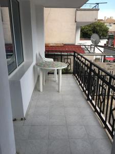 a balcony with a table and a chair on it at Kapka Apartments in Kiten
