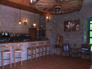 a bar with wooden stools and a brick wall at Casa Notario in Asín de Broto