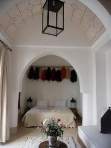 a room with a bed, a mirror, a dresser, and a at Riad Matham in Marrakesh