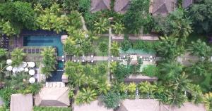 an aerial view of a resort with a swimming pool and trees at The Mansion Resort Hotel & Spa in Ubud