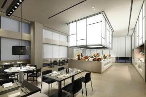 a restaurant with tables and chairs and a kitchen at Shilla Stay Haeundae in Busan