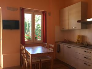 a kitchen with a wooden table and a window at La Casina in Baveno