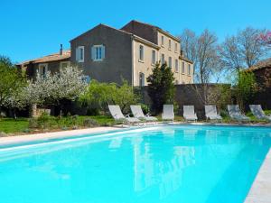 a pool with chairs and a house in the background at LE MANOIR DE CANET D'AUDE in Canet d'Aude