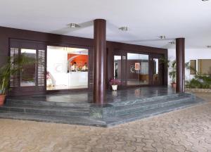 a lobby of a building with glass doors and stairs at Vedic Village Sriperumbudur formerly known as Citrus Hotel in Sriperumbudur