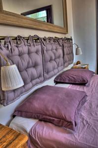 1 Schlafzimmer mit 2 Betten mit lila Kissen und einem Spiegel in der Unterkunft La Ribambelle in Saint-Martin-Vésubie
