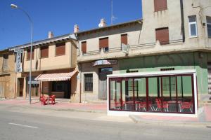 a building on the corner of a city street at Hostal Restaurante Raton in Paredes de Nava