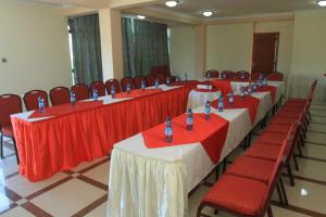 亚的斯亚贝巴Hera Addis Hotel的红白桌布的房间的一排桌椅
