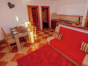 een keuken met een rode bank en een tafel bij Spacious Apartment in Dramalj with Swimming Pool in Dramalj