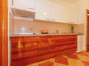 een keuken met houten kasten en sinaasappels op de toonbank bij Spacious Apartment in Dramalj with Swimming Pool in Dramalj