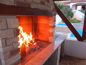 a brick fireplace with a fire in it at Attractive holiday home in Vabriga in Vabriga