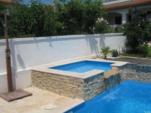 a swimming pool with a stone retaining wall next to a swimming pool at Attractive holiday home in Vabriga in Vabriga