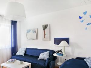 a living room with a blue couch and a table at Delightfully decorated apartment with a sea view 5 minutes to the beach in Brela