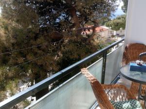 a balcony with a table and chairs and a tree at Charming little apartment with a balcony and a sea view 5 minutes to the beach in Brela