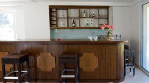 a bar with two stools and a counter with wine bottles at Sani Kasimis in Kyparissia