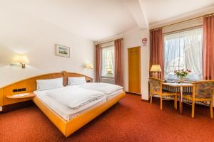a hotel room with a bed and a table at Hotel Goldener Sternen in Konstanz