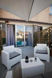 a patio with two white chairs and a table at De Gasperi 55 in Naples